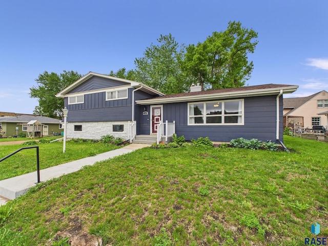 105 S Elm St, Lennox, SD 57039 - split level home featuring a front lawn, board and batten siding, and a chimney