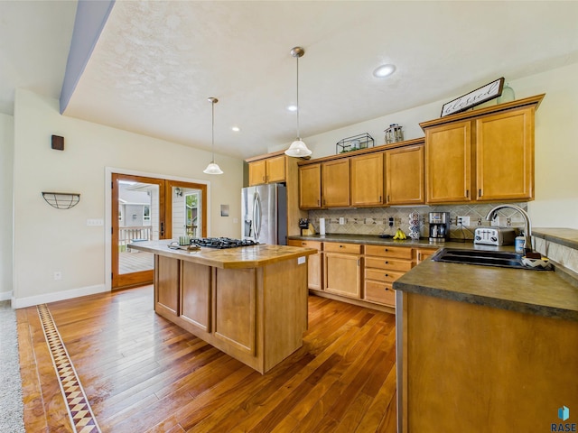 2601 N Devon Ave, Tea, SD 57064 - kitchen featuring stainless steel fridge with ice dispenser, a sink, wood-type flooring, a center island, and tasteful backsplash
