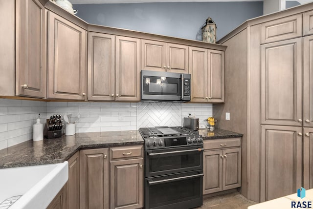 3909 E Shepherd St, Sioux Falls, SD 57103 - kitchen featuring stainless steel microwave, range with two ovens, tasteful backsplash, and dark stone countertops