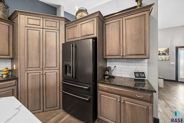 3909 E Shepherd St, Sioux Falls, SD 57103 - kitchen with high end black fridge, wood finished floors, decorative backsplash, and dark stone countertops