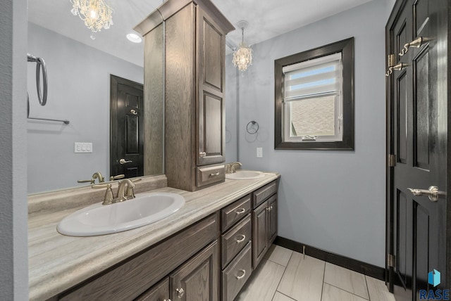 3909 E Shepherd St, Sioux Falls, SD 57103 - full bathroom with double vanity, baseboards, and a chandelier
