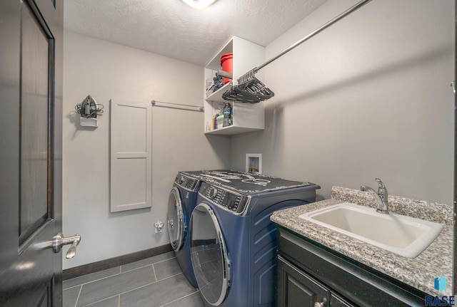 3909 E Shepherd St, Sioux Falls, SD 57103 - washroom featuring a sink, washing machine and clothes dryer, dark tile patterned flooring, a textured ceiling, and baseboards