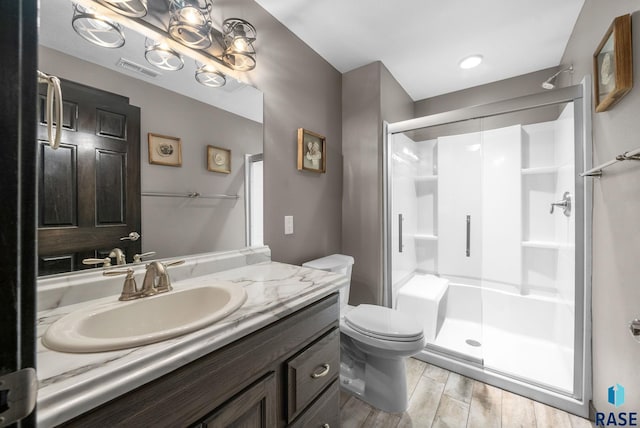 3909 E Shepherd St, Sioux Falls, SD 57103 - bathroom featuring a stall shower, vanity, toilet, and wood finished floors