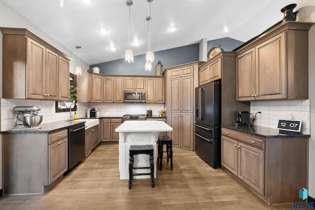 3909 E Shepherd St, Sioux Falls, SD 57103 - kitchen featuring stainless steel appliances, vaulted ceiling, a sink, tasteful backsplash, and light wood-style floors