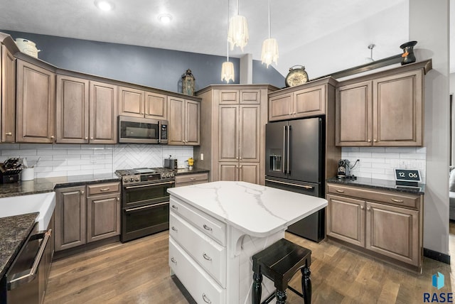 3909 E Shepherd St, Sioux Falls, SD 57103 - kitchen featuring high quality appliances, backsplash, dark wood-style floors, dark stone countertops, and lofted ceiling