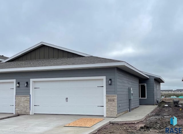 3408 S Heather Ave, Sioux Falls, SD 57106 - view of side of property with stone siding, driveway, an attached garage, and roof with shingles