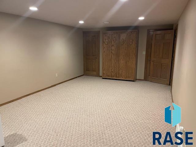 218 S Douglas St, Inwood, IA 51240 - unfurnished bedroom with light colored carpet, recessed lighting, and baseboards