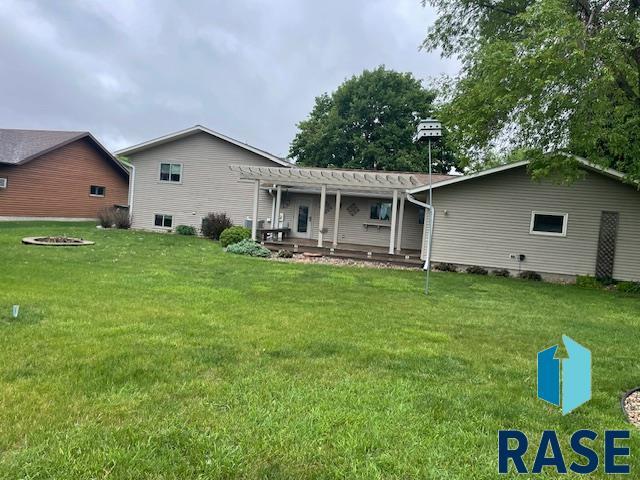 218 S Douglas St, Inwood, IA 51240 - back of house with a pergola, a lawn, and a fire pit