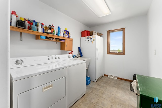 39240 210th St, Huron, SD 57350 - laundry room featuring washer and dryer, baseboards, and light tile patterned floors