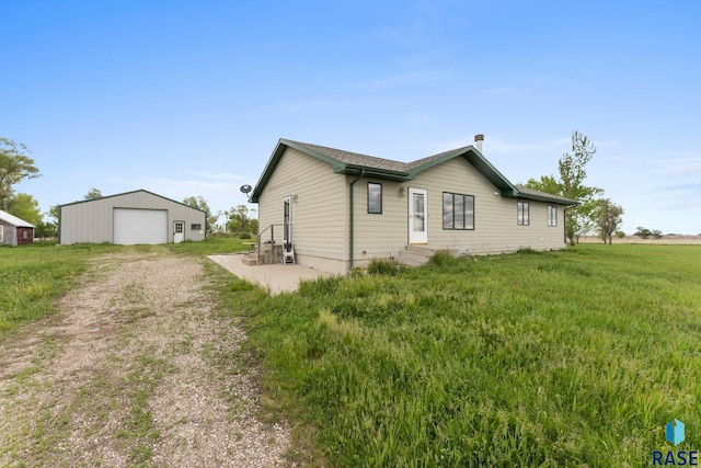 39240 210th St, Huron, SD 57350 - view of home's exterior with a garage, dirt driveway, an outdoor structure, and entry steps