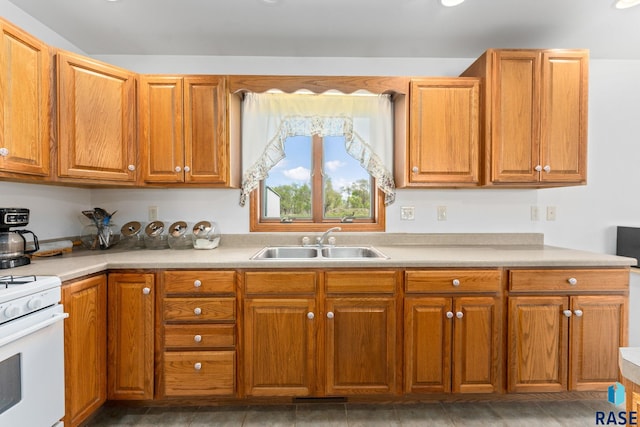 39240 210th St, Huron, SD 57350 - kitchen featuring a sink, white gas range oven, light countertops, and brown cabinetry