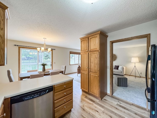 2405 E 51st St, Sioux Falls, SD 57103 - kitchen featuring dishwasher, black fridge, light wood finished floors, a chandelier, and light countertops
