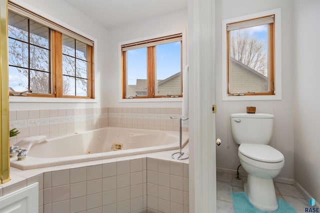 7005 W Strabane Trl, Sioux Falls, SD 57106 - bathroom with a jetted tub, toilet, plenty of natural light, and baseboards