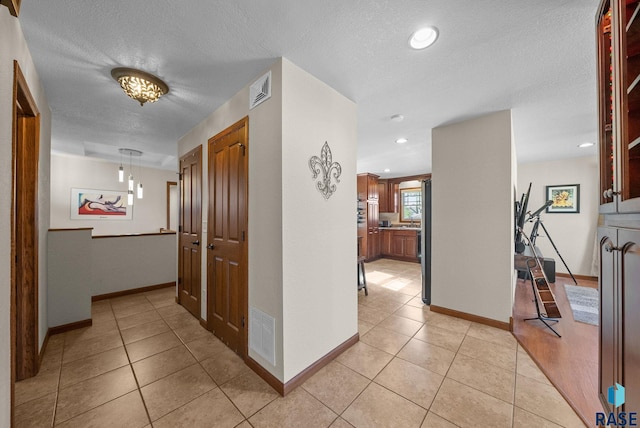 912 N Minnesota Ave, Sioux Falls, SD 57104 - hallway featuring light tile patterned floors, baseboards, a textured ceiling, and recessed lighting