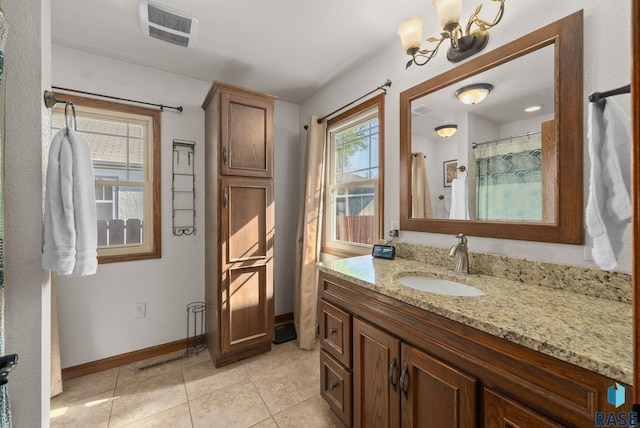 912 N Minnesota Ave, Sioux Falls, SD 57104 - full bathroom featuring vanity, baseboards, tile patterned floors, and a chandelier