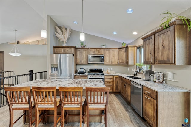 1716 E Tracy Ln, Sioux Falls, SD 57103 - kitchen with appliances with stainless steel finishes, a sink, vaulted ceiling, light wood-type flooring, and decorative light fixtures