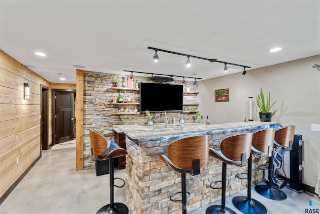 1716 E Tracy Ln, Sioux Falls, SD 57103 - indoor wet bar featuring finished concrete flooring, wooden walls, recessed lighting, and track lighting