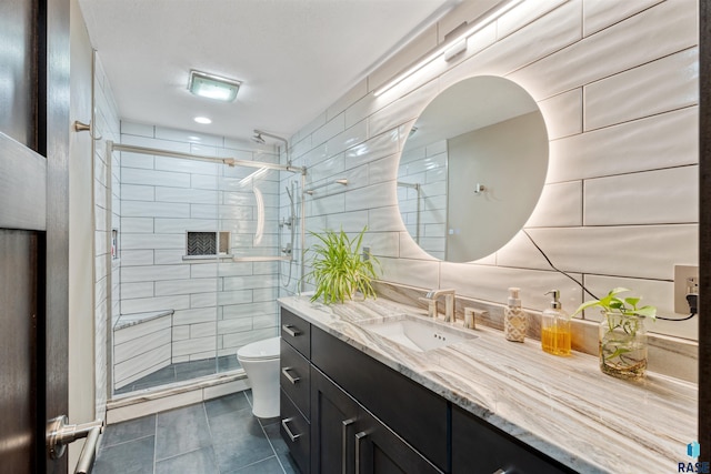 1716 E Tracy Ln, Sioux Falls, SD 57103 - full bath with toilet, vanity, tile patterned floors, a stall shower, and tile walls