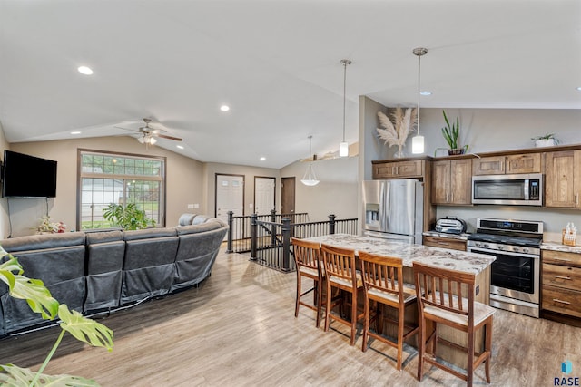 1716 E Tracy Ln, Sioux Falls, SD 57103 - kitchen with stainless steel appliances, vaulted ceiling, light wood-style flooring, open floor plan, and ceiling fan