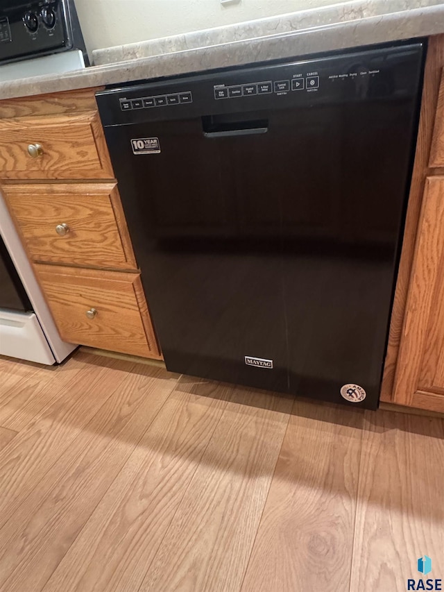 300 W Pipestone Ave, Flandreau, SD 57028 - kitchen view of black dishwasher, brown cabinetry, and light wood-style flooring