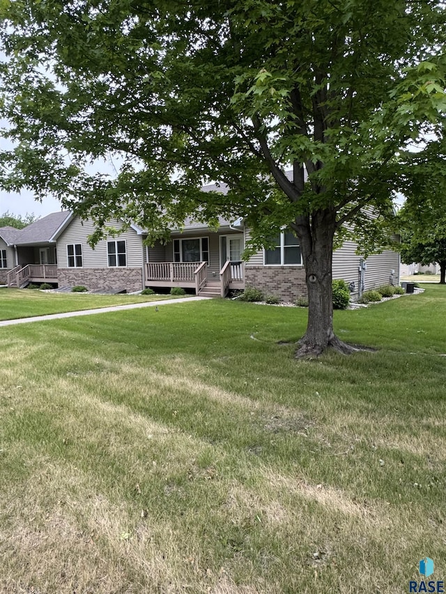 300 W Pipestone Ave, Flandreau, SD 57028 - view of front of home with a porch, a front lawn, and stone siding