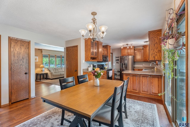 4201 E 22nd St, Sioux Falls, SD 57103 - dining room featuring wood finished floors, a chandelier, and a textured ceiling