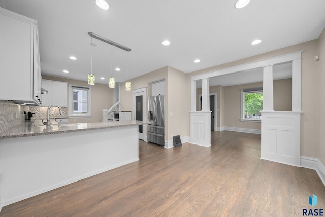 809 S Duluth Ave, Sioux Falls, SD 57104 - kitchen with stainless steel fridge with ice dispenser, a sink, a peninsula, light stone countertops, and recessed lighting