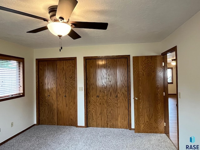 502 E 4th St, Canton, SD 57013 - unfurnished bedroom featuring multiple closets, carpet floors, baseboards, and a ceiling fan