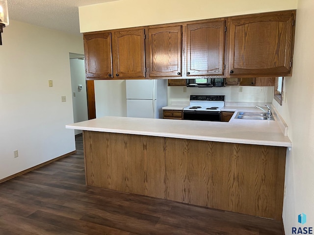 502 E 4th St, Canton, SD 57013 - kitchen with electric stove, black microwave, freestanding refrigerator, a sink, and a peninsula