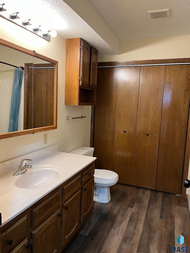 502 E 4th St, Canton, SD 57013 - bathroom with vanity, wood finished floors, toilet, a shower with curtain, and a textured ceiling