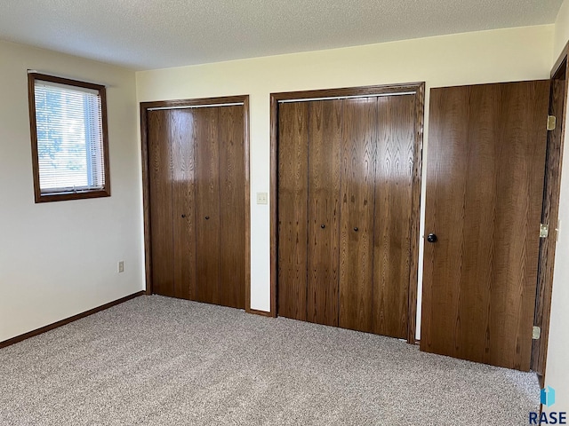 502 E 4th St, Canton, SD 57013 - unfurnished bedroom featuring multiple closets, carpet flooring, and baseboards