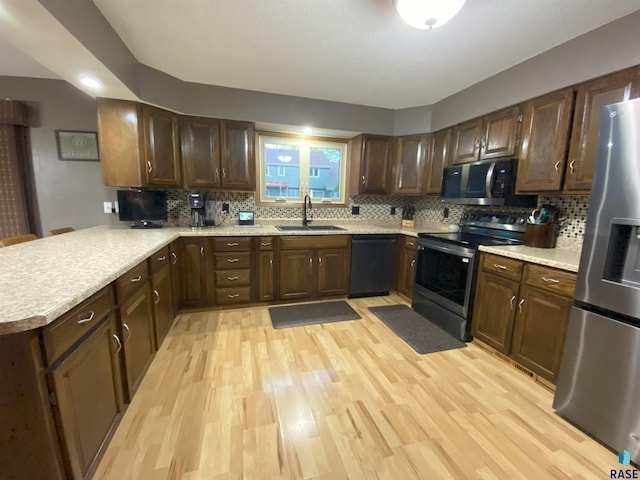 4604 S Woodwind Ln, Sioux Falls, SD 57103 - kitchen featuring appliances with stainless steel finishes, a sink, and light wood-style flooring