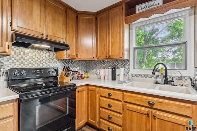 6501 W 46th St, Sioux Falls, SD 57106 - kitchen with black electric range, under cabinet range hood, a sink, decorative backsplash, and light countertops