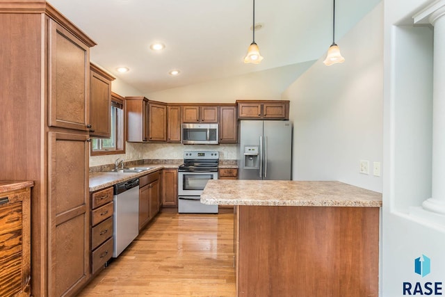 5205 S Culbert Ave, Sioux Falls, SD 57106 - kitchen featuring appliances with stainless steel finishes, lofted ceiling, light wood-style flooring, a peninsula, and decorative light fixtures