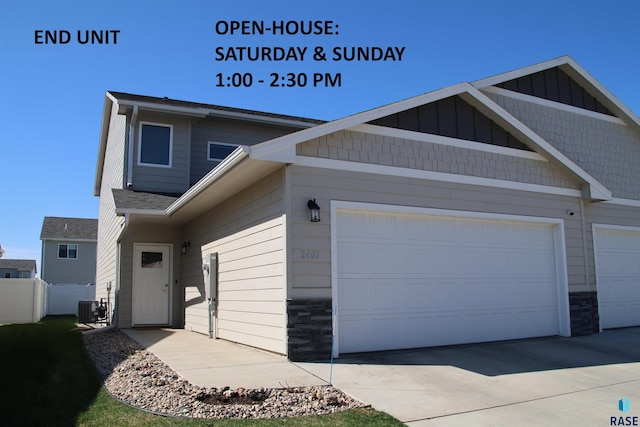 2407 E Copalis Pl, Sioux Falls, SD 57108 - view of front of house featuring cooling unit, a garage, stone siding, board and batten siding, and driveway