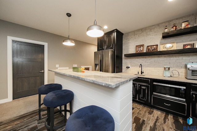 8609 E Fiddlewood Dr, Sioux Falls, SD 57110 - kitchen with stainless steel appliances, open shelves, light stone counters, a kitchen breakfast bar, and decorative backsplash