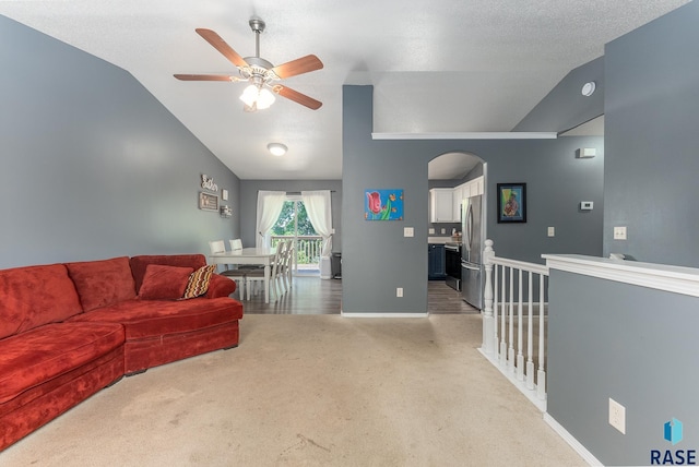 7104 W 68th St, Sioux Falls, SD 57106 - living area with vaulted ceiling, a ceiling fan, arched walkways, light colored carpet, and baseboards