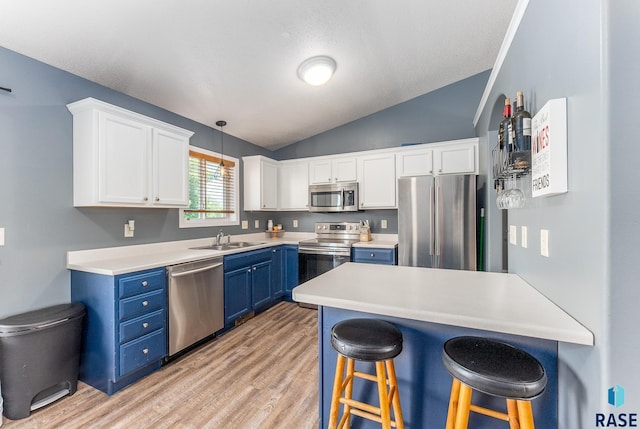 7104 W 68th St, Sioux Falls, SD 57106 - kitchen with appliances with stainless steel finishes, blue cabinets, a sink, a breakfast bar, and lofted ceiling