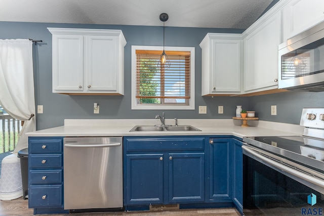 7104 W 68th St, Sioux Falls, SD 57106 - kitchen with appliances with stainless steel finishes, a sink, blue cabinets, white cabinets, and light countertops