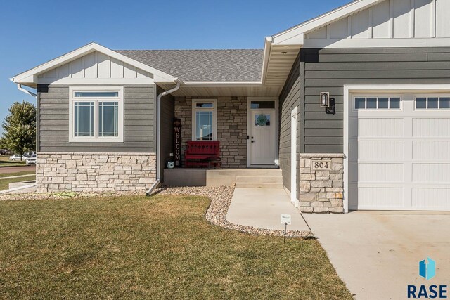 804 Johnson Creek Ct, Harrisburg, SD 57032 - view of front of home with stone siding, board and batten siding, a front lawn, and a garage