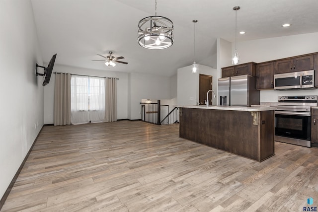 9509 W Liam St, Sioux Falls, SD 57106 - kitchen featuring stainless steel appliances, dark brown cabinetry, light wood-type flooring, ceiling fan, and high vaulted ceiling