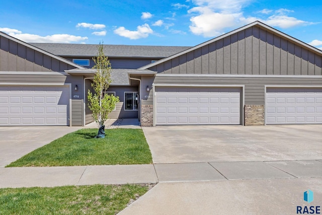4314 W Shipton St, Sioux Falls, SD 57108 - view of property with brick siding, concrete driveway, a garage, and board and batten siding