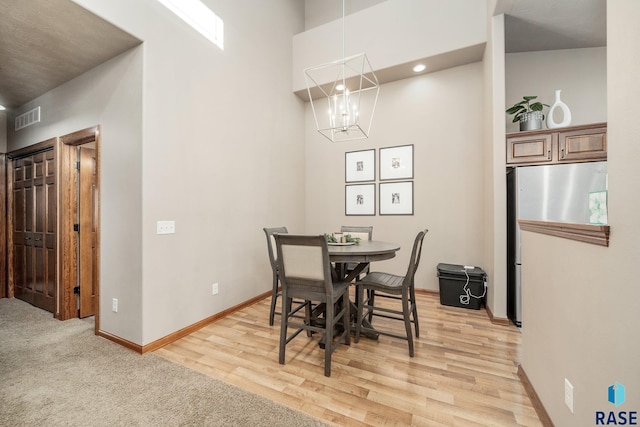 4314 W Shipton St, Sioux Falls, SD 57108 - dining room with a chandelier, baseboards, light wood finished floors, and a towering ceiling