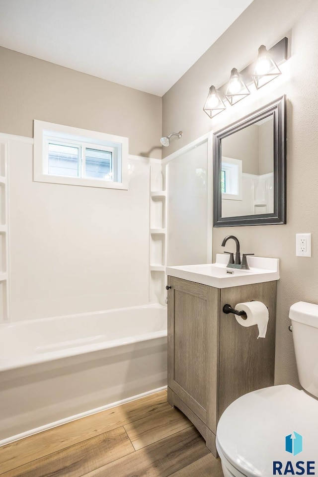 1205 W 14th St, Sioux Falls, SD 57104 - bathroom with toilet, shower / washtub combination, wood finished floors, and vanity