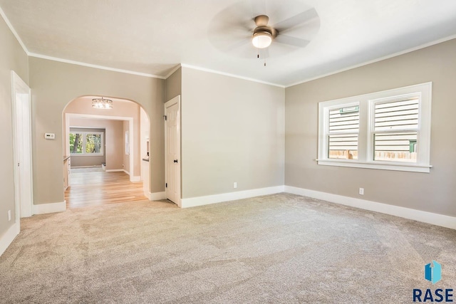 1205 W 14th St, Sioux Falls, SD 57104 - empty room featuring light carpet, ceiling fan, arched walkways, ornamental molding, and baseboards