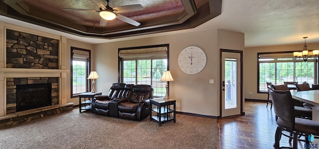 2813 W Stratton Cir, Sioux Falls, SD 57108 - living room featuring a chandelier, ceiling fan, a raised ceiling, baseboards, and wood-type flooring