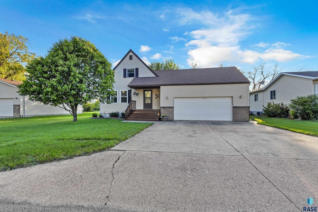 811 N Cedar St, Canton, SD 57013 - traditional-style house featuring a garage, driveway, a front yard, and brick siding
