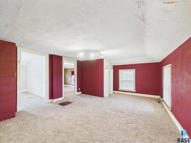 45390 284th St, Hurley, SD 57036 - empty room featuring a textured ceiling, carpet flooring, and baseboards
