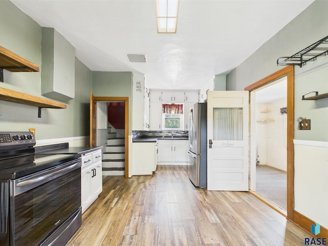 45390 284th St, Hurley, SD 57036 - kitchen with appliances with stainless steel finishes, light wood-style flooring, white cabinets, dark countertops, and open shelves