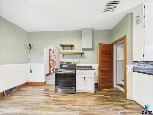 45390 284th St, Hurley, SD 57036 - kitchen with stainless steel electric stove, white cabinets, light wood-type flooring, arched walkways, and open shelves
